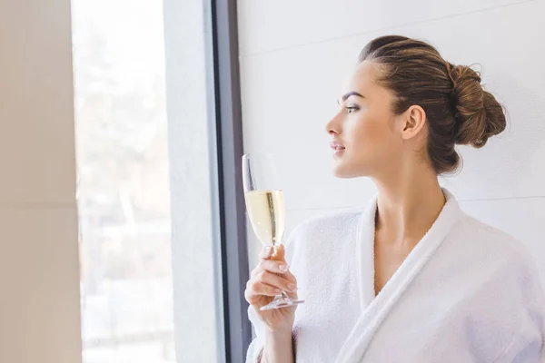 Retrato de mulher bonita em roupão de banho com copo de champanhe em casa — Fotografia de Stock
