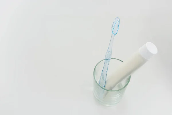 Close up view of toothbrush and paste in glass — Stock Photo