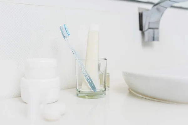 Close up view of toothbrush and paste in glass — Stock Photo