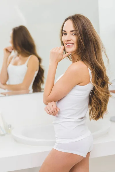 Улыбающаяся красивая женщина в ванной комнате дома — стоковое фото