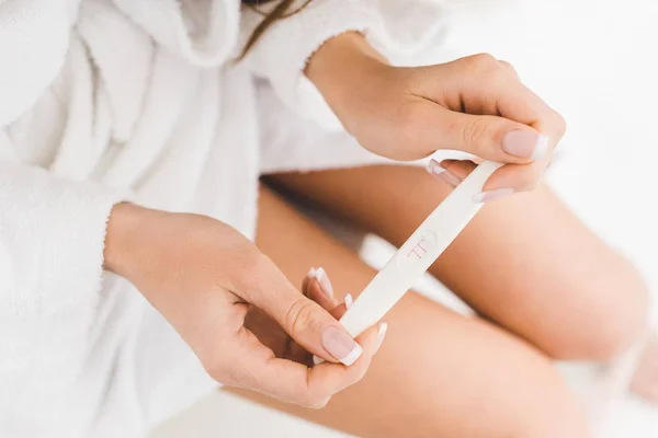 Partial view of woman holding pregnancy test in hands — Stock Photo