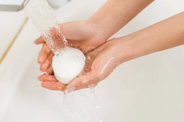 Vista parcial de la mujer lavándose las manos con jabón en casa - foto de stock