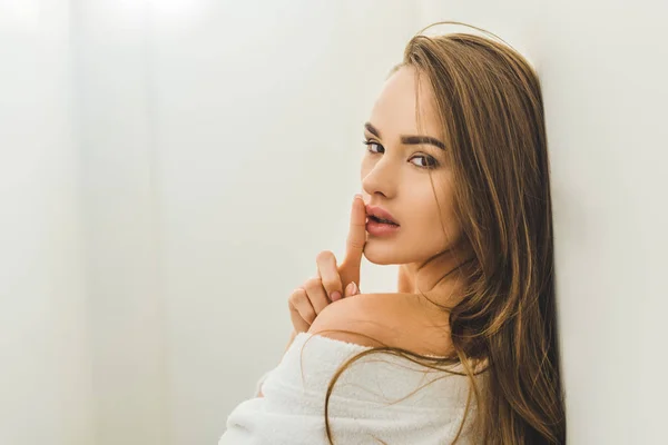 Side view of attractive young woman with silence symbol in bathrobe at home — Stock Photo