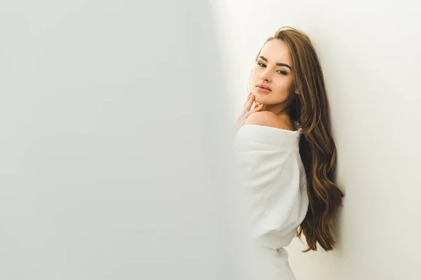 Attractive young woman in bathrobe looking at camera — Stock Photo