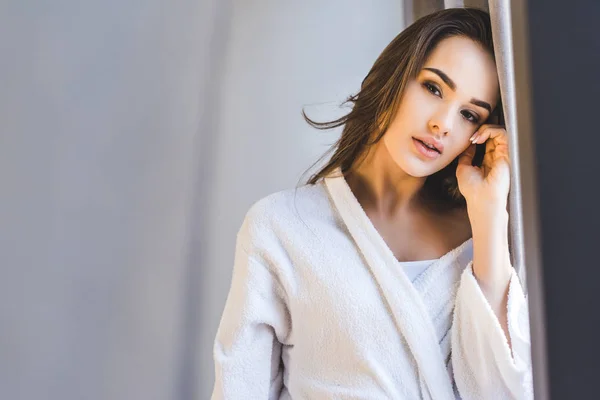 Portrait of attractive young woman in bathrobe at home — Stock Photo