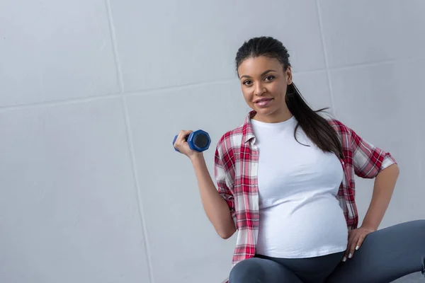 African american pregnant woman training with dumbbell — Stock Photo