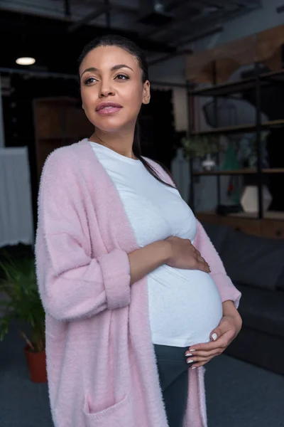 Mujer embarazada afroamericana tocando su vientre - foto de stock