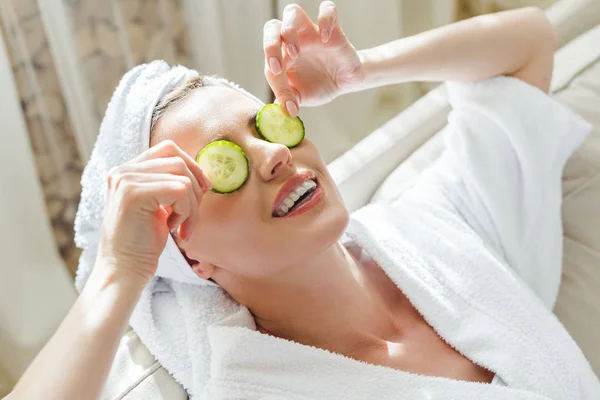 Woman relaxing with cucumber slices on eyes — Stock Photo