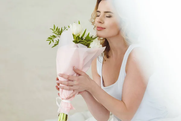 Hermosa mujer oliendo ramo de flores para el día internacional de la mujer - foto de stock