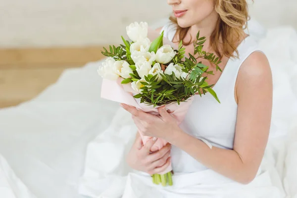 Vista ritagliata della donna con mazzo di fiori per la giornata internazionale delle donne — Foto stock