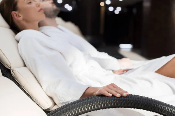 Selective focus of couple in bathrobes resting together in spa center — Stock Photo