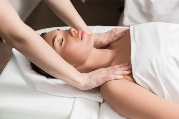 Jeune femme détendue avec les yeux fermés ayant massage du corps dans le salon de spa — Photo de stock