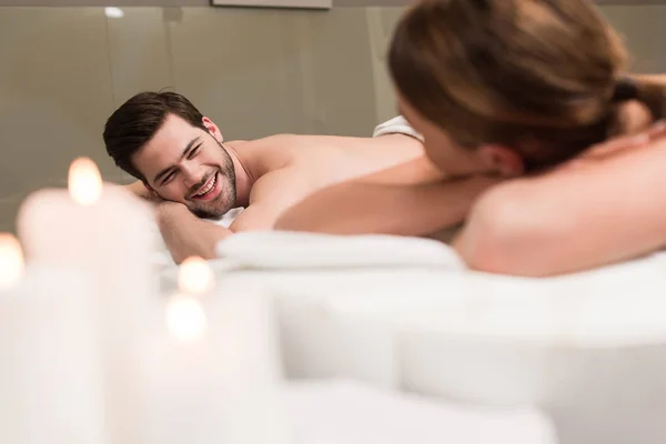 Oung couple looking at each other during massage in spa salon — Stock Photo