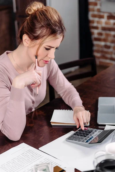 Side view of woman making calculations at table at home, financial problems concept — Stock Photo