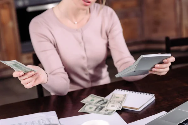 Cropped shot of woman counting money at table at home — Stock Photo