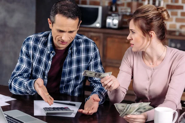 Retrato do casal contando dinheiro enquanto sentado à mesa em casa, conceito de problemas financeiros — Fotografia de Stock