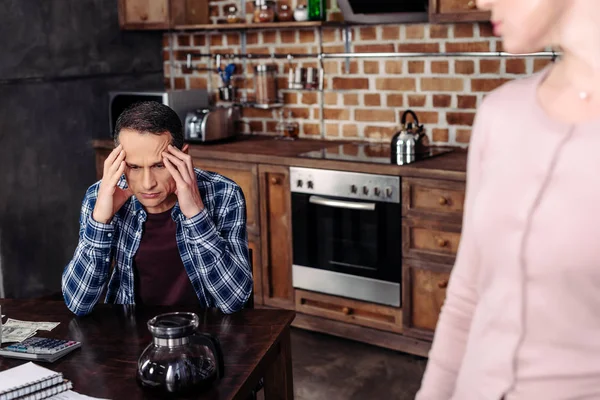 Selective focus of woman looking at pensive husband at table at home, financial problems concept — Stock Photo