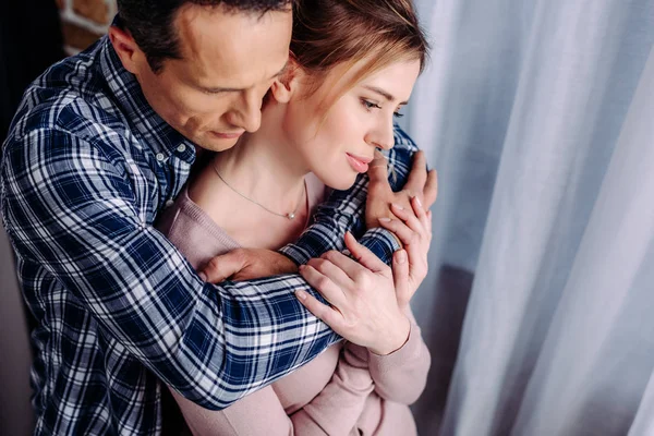 Высокий угол зрения мужа, обнимающего жену дома — стоковое фото