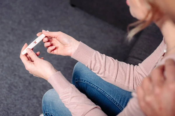 Vue partielle de l'homme étreignant femme avec test de grossesse dans les mains — Photo de stock