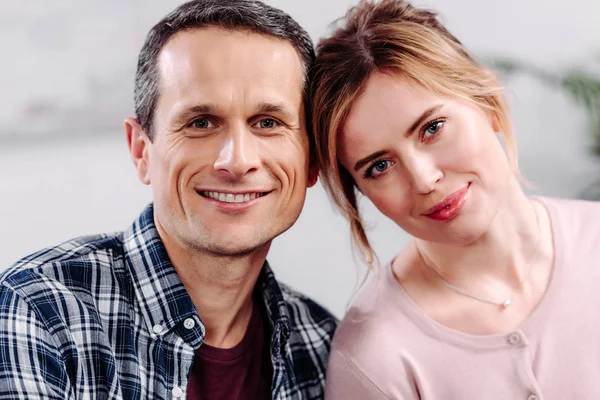 Портрет усміхненої пари закоханих, дивлячись на камеру вдома — стокове фото