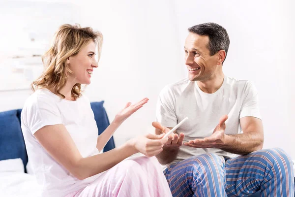 Retrato de esposa feliz con prueba de embarazo y marido en casa - foto de stock