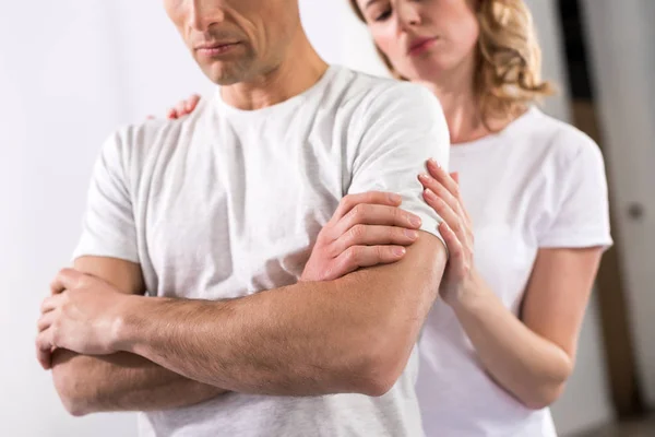Schnappschuss von Ehefrau, die ihren verärgerten Ehemann zu Hause umarmt — Stockfoto