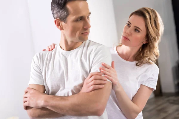 Retrato de la esposa abrazando molesto marido en casa — Stock Photo