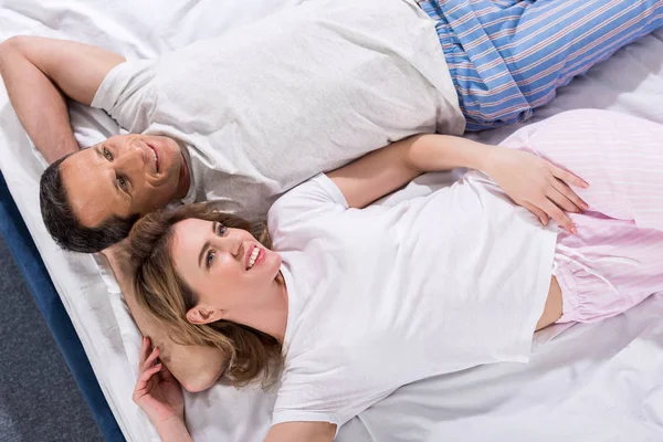Вид улыбающейся влюбленной пары, отдыхающей вместе в постели — стоковое фото