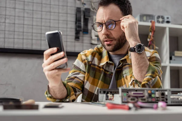 Mann benutzt smatphone, während er am Tisch sitzt — Stockfoto