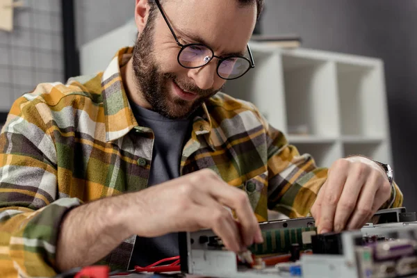 Homme souriant dans des lunettes ordinateur de fixation — Photo de stock