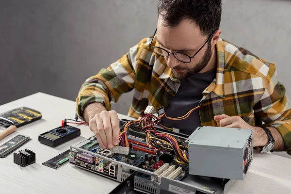 Homem ajustando detalhes durante a fixação de computador — Fotografia de Stock