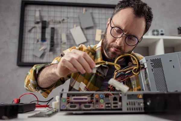 Uomo che regola i dettagli durante il fissaggio del computer — Foto stock