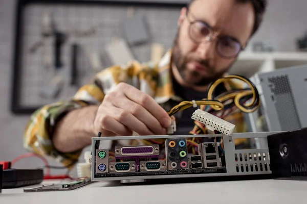 Человек настраивает провода на сломанном компьютере — стоковое фото