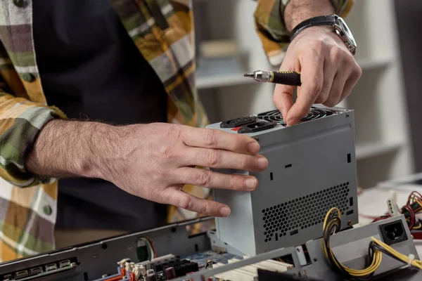 Man with screwdriver in hand fixing computer part — Stock Photo