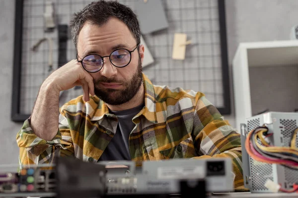 Discouraged repairman looking at broken pc — Stock Photo