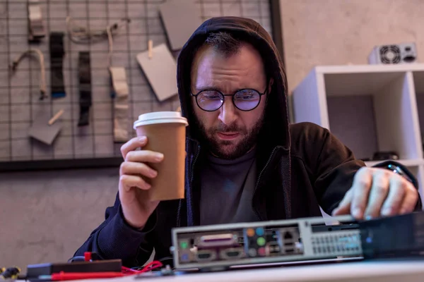 Homem com café na mão olhando no pc quebrado — Fotografia de Stock