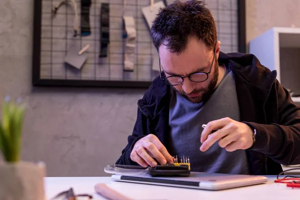 Man choosing attachments to screwdriver over digital tablet — Stock Photo