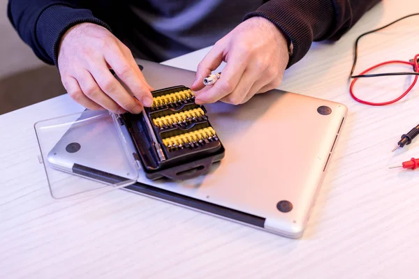 Imagen recortada de las manos y los accesorios al destornillador sobre la tableta digital - foto de stock