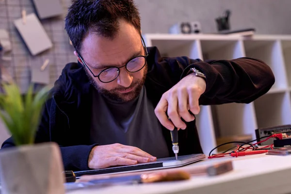 Caucasian man with screwdriver fixing digital tablet — Stock Photo