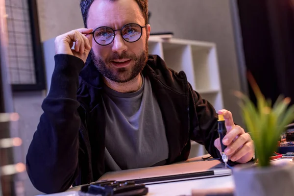 Uomo con mano su occhiali utilizzando cacciavite durante il fissaggio tablet digitale — Foto stock