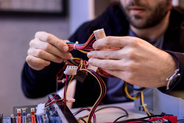 Imagen recortada del hombre sosteniendo cables en las manos - foto de stock