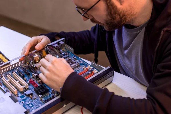 Homem em óculos fixação quebrado computador placa-mãe — Fotografia de Stock