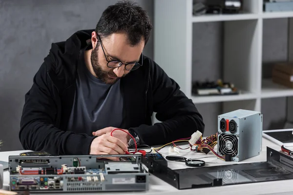 Uomo utilizzando multimetro durante il fissaggio pc rotto — Foto stock