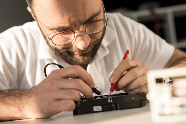 Homem usando multímetro ao testar a unidade de disco rígido — Fotografia de Stock