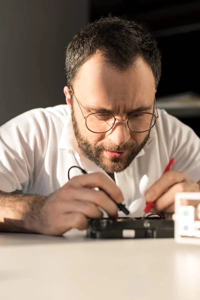 Mann benutzt Multimeter beim Testen der Festplatte — Stockfoto