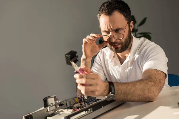 Homme regardant sur les détails de l'ordinateur en main — Photo de stock