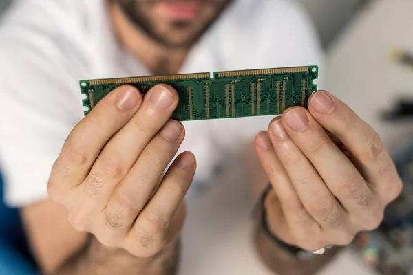 Cropped image of man holding ram card in hands — Stock Photo