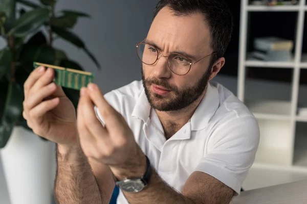 Homme regardant la mémoire de bélier dans ses mains — Photo de stock