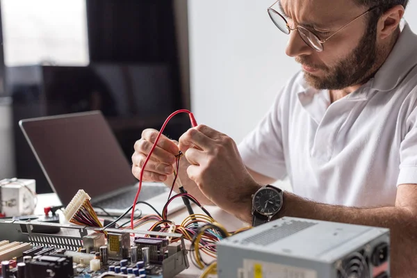 Uomo utilizzando multimetro durante il fissaggio del computer rotto — Foto stock