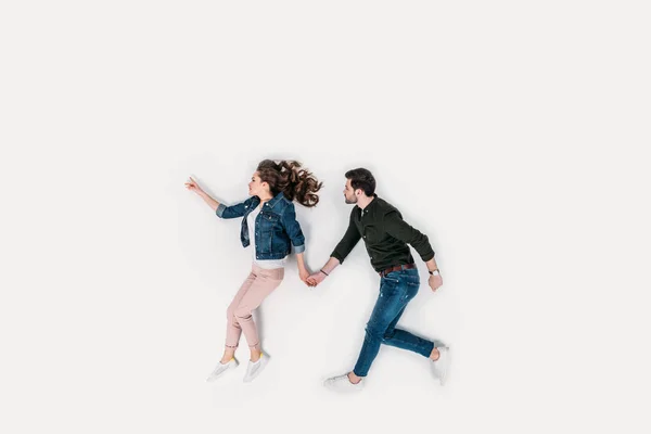 Vista superior de la pareja caminando y tomados de las manos aislados en blanco - foto de stock